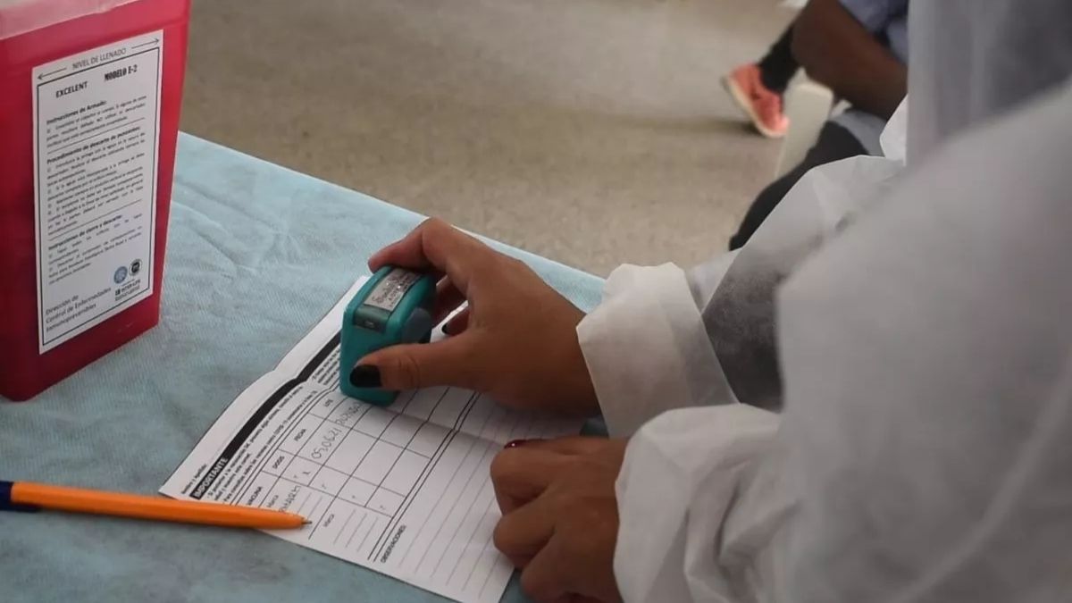Una trabajadora de salud sella un carnet de vacunación contra el covid-19 en Jujuy. /Foto: Prensa Gobernación