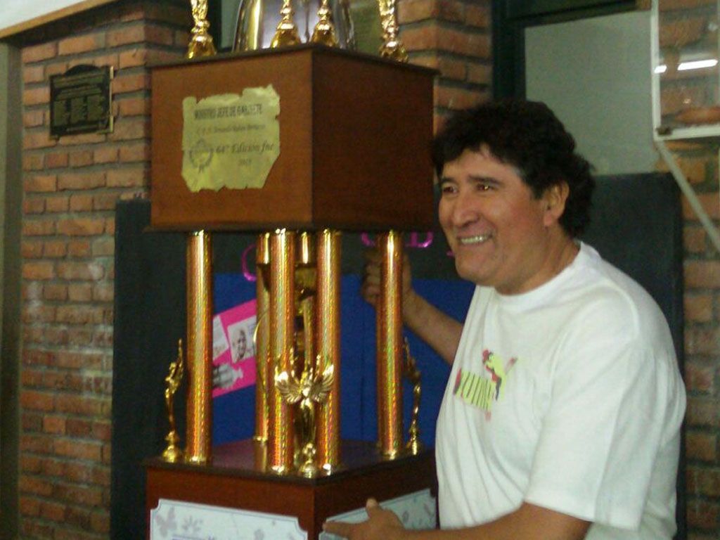 El "Dire" Hugo Flores junto al premio