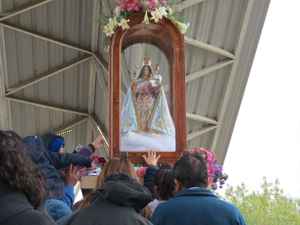 Fieles tocando la imagen de la Virgen