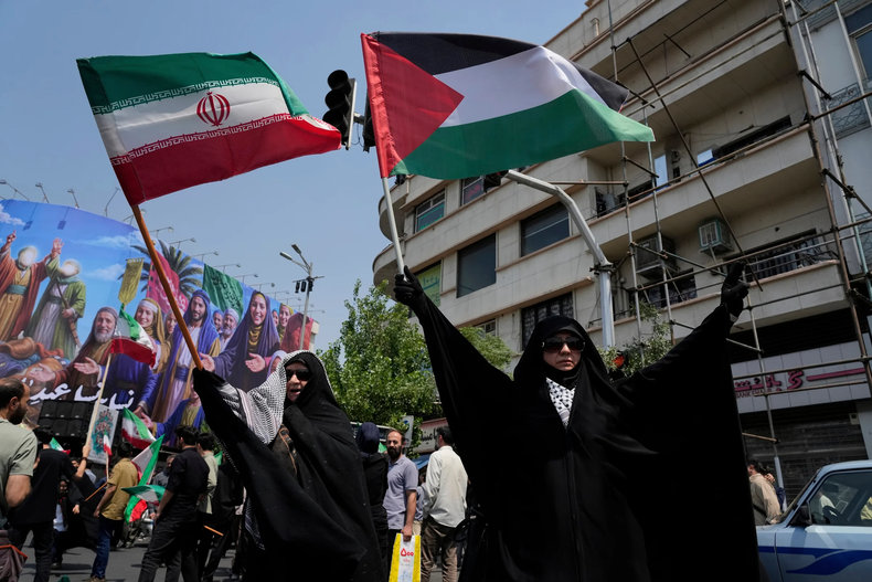 Manifestantes iraníes ondean banderas de Irán y Palestina en una concentración contra Israel en Teherán, Irán, el 13 de junio de 2025. (AP Foto/Vahid Salemi)