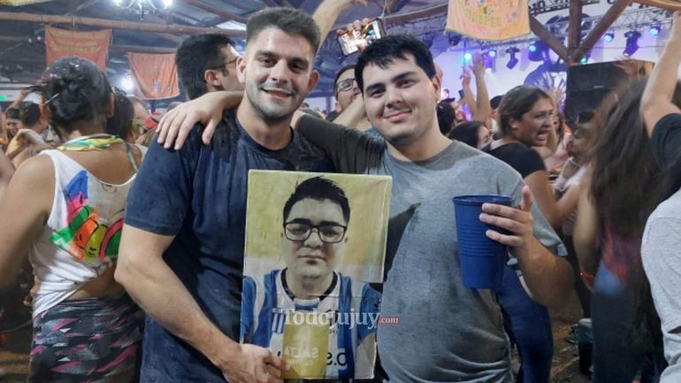 Amigos cordobeses con la fotografía de su amigo que no pudo venir