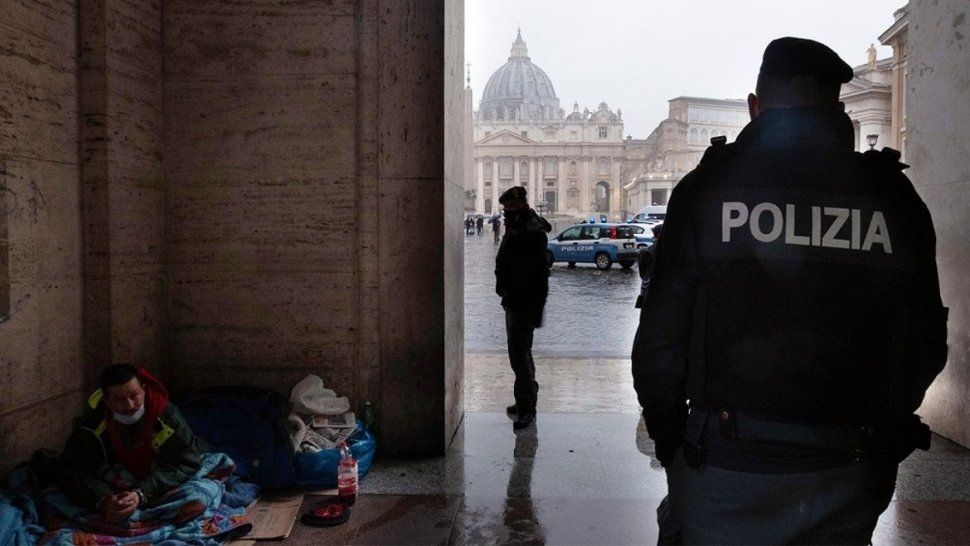 Un soldado y un mendigo cerca de la catedral de San Pedro, en el Vaticano.