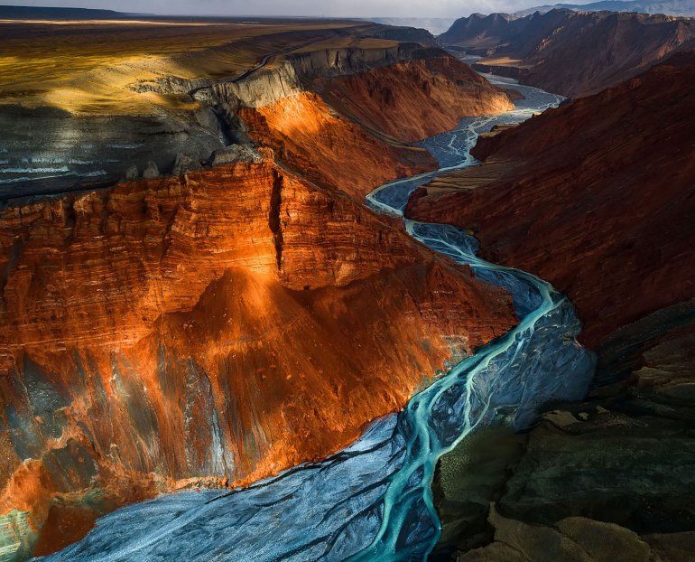La luz del sol se asoma a las capas minerales de diferentes colores en el Gran Cañón de Dushanzi, China.