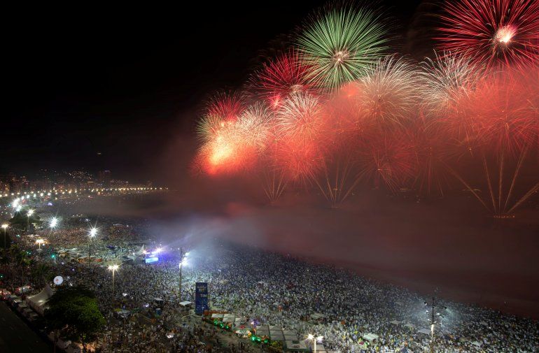 La gente observa c&oacute;mo los fuegos artificiales explotan en la playa de Copacabana durante las celebraciones de A&ntilde;o Nuevo en R&iacute;o de Janeiro, Brasil, el 1 de enero de 2020. (REUTERS&nbsp; Ueslei Marcelino)