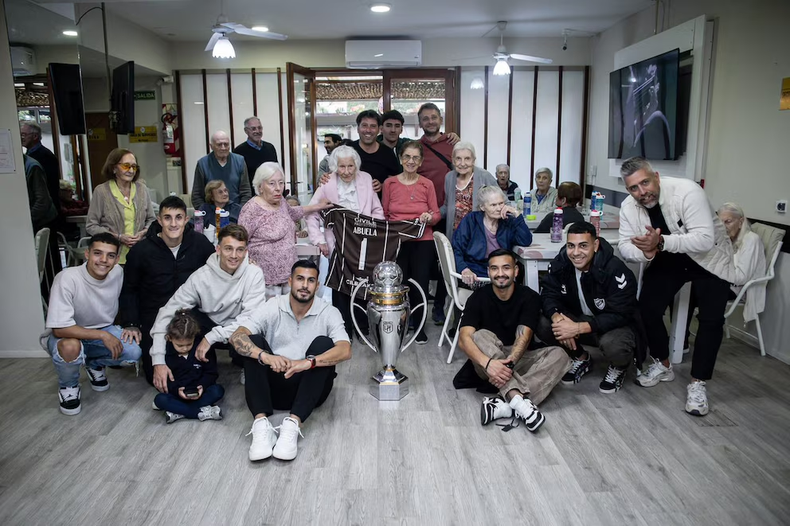 La abuela junto a otros adultos mayores con el plantel de Platense.