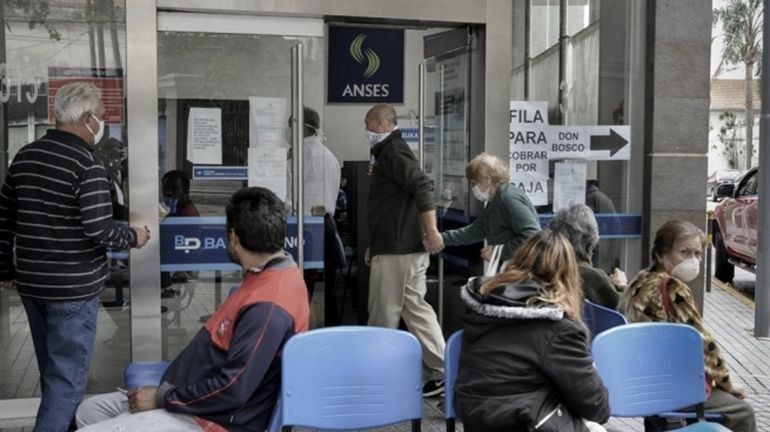 Fila. Un grupo de personas espera a ser atendida en una sucursal de la Anses. Los beneficiarios podrán cobrar el bono con tarjeta de débito o a través del cajero humano.