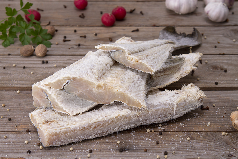 Cortar las tajadas de bacalao. Si prefieren pueden hacerlo con bacalao fresco. Para esta receta yo prefiero cortar tiras alargadas y finas del lomo del bacalao para repartirlas mejor.